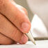 small image of person writing with pen